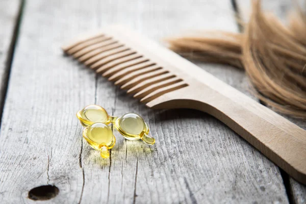 Догляд за волоссям. вітамінна сироваткова капсула на дерев'яному фоні — стокове фото