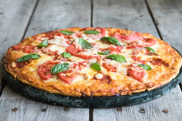 Sıcak ev yapımı Pepperoni Pizza bir rustik ahşap tablo. 