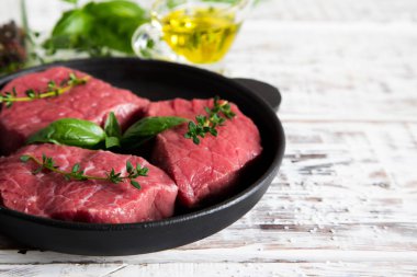 zeytinyağı ile ışık ahşap arka plan üzerinde ham sığır eti biftek 