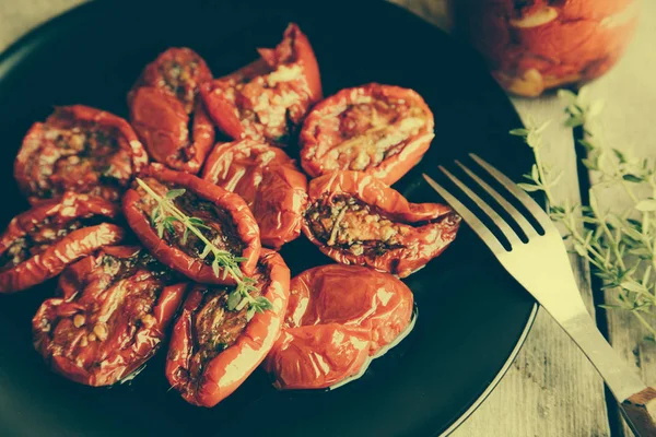 Kom van zon gedroogde tomaten op houten achtergrond. — Stockfoto