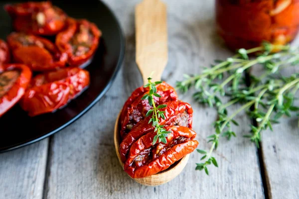 Güneş kase domates ahşap arka plan üzerinde kurutulmuş. 