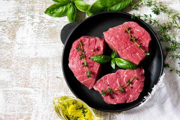 zeytinyağı ile ışık ahşap arka plan üzerinde ham sığır eti biftek 