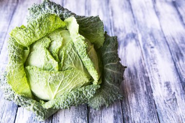 Ahşap arka plan üzerinde ham savoy lahana. Organik gıda