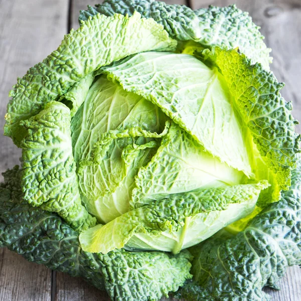 Ahşap arka plan üzerinde ham savoy lahana. Organik gıda
