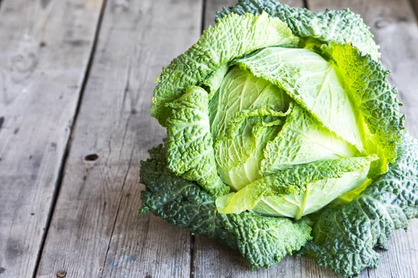 Ahşap arka plan üzerinde ham savoy lahana. Organik gıda