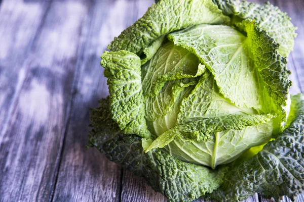 Ahşap arka plan üzerinde ham savoy lahana. Organik gıda