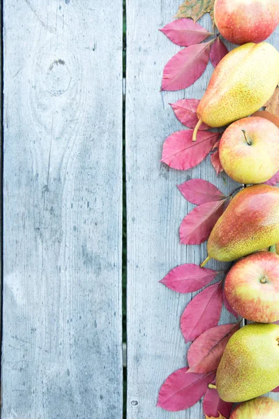 elma, armut ve ahşap arka plan üzerinde sonbahar yaprakları. 