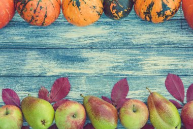 kabak, elma, armut ve sonbahar yaprakları üzerinde ahşap arka plan. 