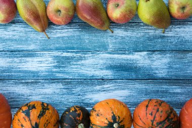 kabak, elma, armut ve sonbahar yaprakları üzerinde ahşap arka plan. 