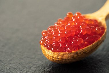 bir kaşık siyah arduvaz arka plan üzerinde kırmızı havyar