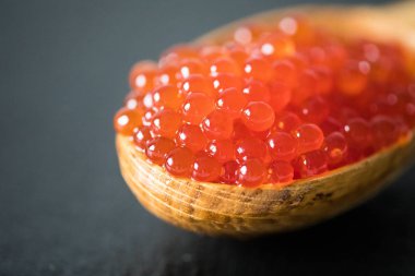 bir kaşık siyah arduvaz arka plan üzerinde kırmızı havyar