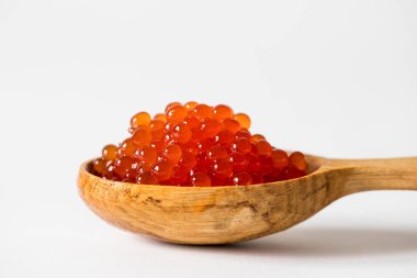 Beyaz arka planda kaşıkta kırmızı havyar