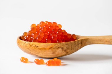 Beyaz arka planda kaşıkta kırmızı havyar