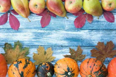 kabak, elma, armut ve sonbahar yaprakları üzerinde ahşap arka plan. 