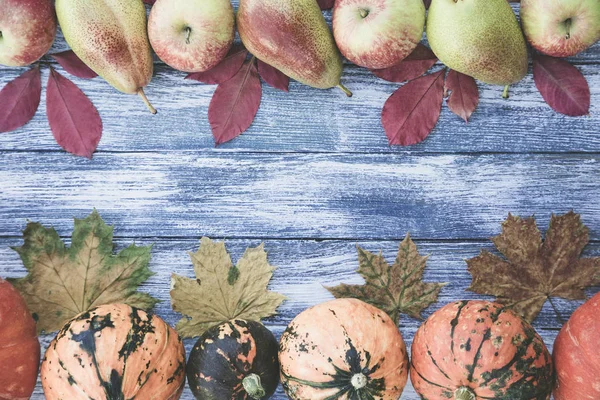 kabak, elma, armut ve sonbahar yaprakları üzerinde ahşap arka plan. 
