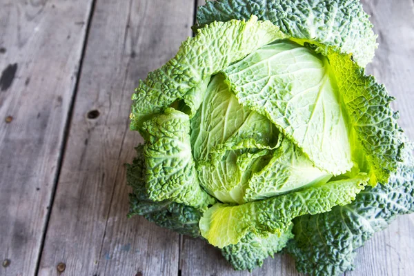 Ahşap arka plan üzerinde ham savoy lahana. Organik gıda