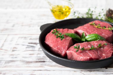 zeytinyağı ve s hafif bir ahşap zemin üzerine ham sığır eti biftek
