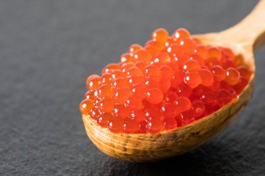 bir kaşık siyah arduvaz arka plan üzerinde kırmızı havyar