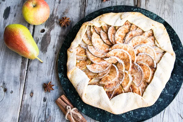 Kuchen mit Äpfeln, Birnen und Zimt auf altem Holzgrund — Stockfoto