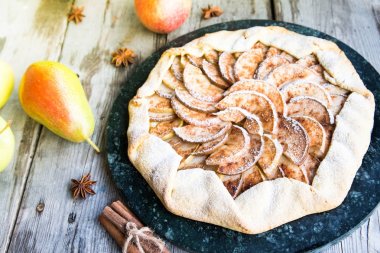 Elma, armut ve eski bir ahşap zemin üzerine tarçın pasta