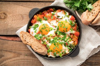 Yumurta, domates ve maydanoz demir tavada Shakshuka. 