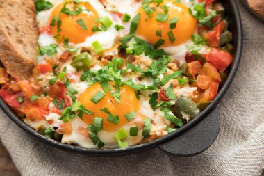 Yumurta, domates ve maydanoz demir tavada Shakshuka. 