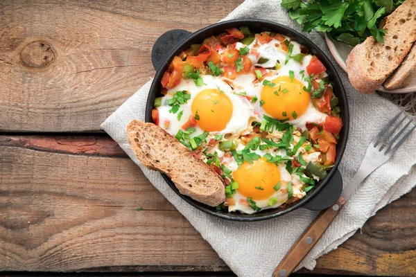 Shakshuka com ovos, tomate e salsa em uma panela de ferro . — Fotografia de Stock