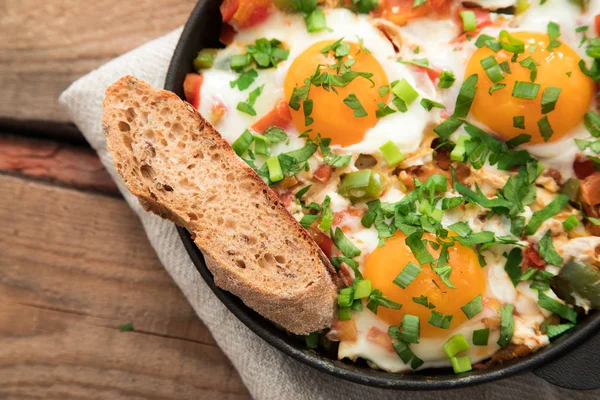 Shakshuka com ovos, tomate e salsa em uma panela de ferro . — Fotografia de Stock