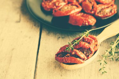 Güneş kase domates ahşap arka plan üzerinde kurumuş. Tomat kurutulmuş