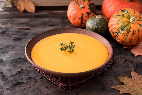 Zuppa di purea di zucca con timo su uno sfondo di legno scuro . — Foto Stock