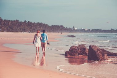 Mutlu genç çiftin bir ıssız tropikal b üzerinde yürüme arkadan görünüm
