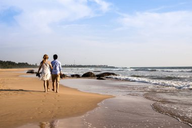 Mutlu genç çiftin bir ıssız tropikal b üzerinde yürüme arkadan görünüm
