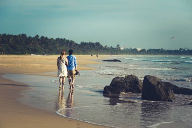 Mutlu genç çiftin bir ıssız tropikal b üzerinde yürüme arkadan görünüm