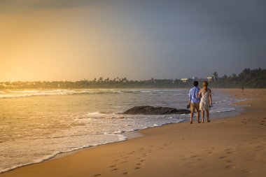 Mutlu genç çiftin bir ıssız tropikal b üzerinde yürüme arkadan görünüm