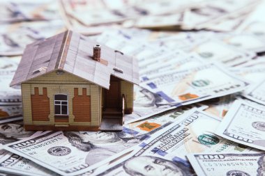 İpotek kavramı. ev ve para. Minyatür ev modeli üzerinde kazık