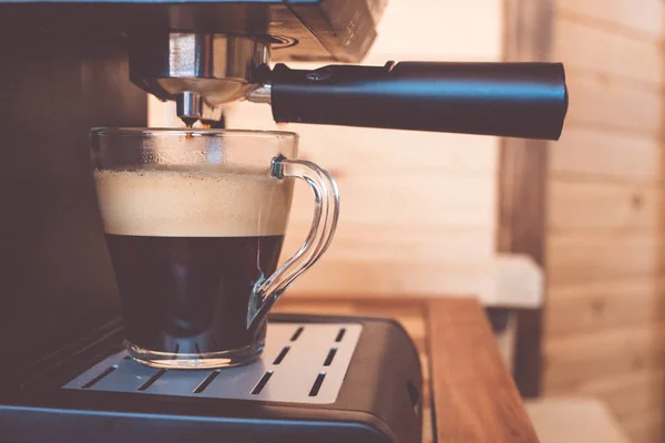 espresso machine pouring strong looking fresh coffee in a  glass