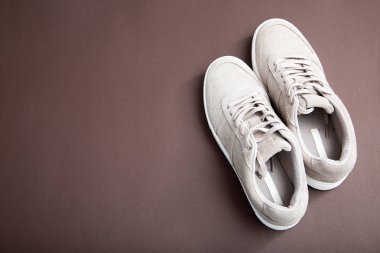 Kahverengi bir arka plan üzerinde Pastel bej spor ayakkabı. Düz yatıyordu, en az b