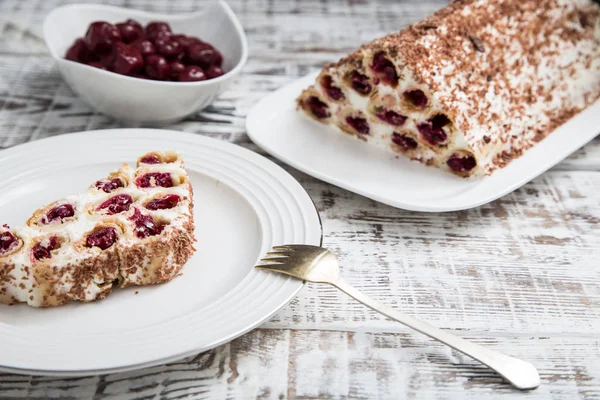 Kuchen mit Kirschen, Sahne und Schokolade auf einem hellen Holzbackgr — Stockfoto