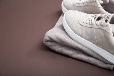 Kahverengi bir arka plan üzerinde Pastel bej spor ayakkabı. Düz yatıyordu, en az b