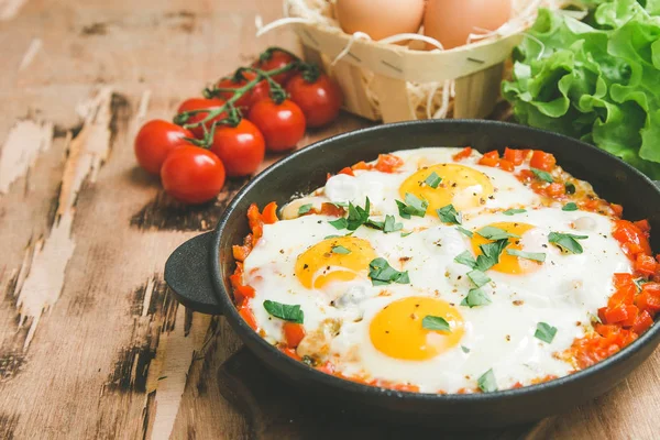 Saboroso e saudável Shakshuka em uma frigideira. Ovos fritos com Tom — Fotografia de Stock