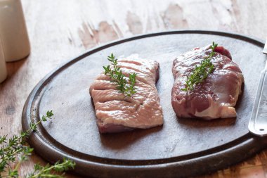 otlar ve baharatlar ile bir kesme tahtası üzerinde ham ördek göğsü.