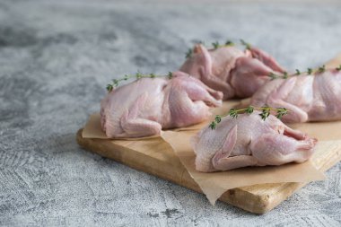 Çiğ bıldırcın. Çiğ et bıldırcınları fotokopi alanı olan bir kesme tahtasında pişirmeye hazır.