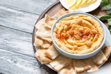 Bir kase ev yapımı kremalı humus zeytinyağı ve pide cipsi. Geleneksel vejetaryen sağlıklı yemek.