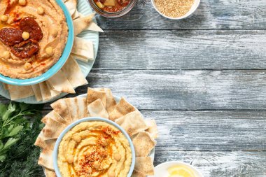 Çeşitli humuslar. Susamlı geleneksel humus ve kırmızı biber ve kurutulmuş domatesli humus. Geleneksel vejetaryen sağlıklı yemek.