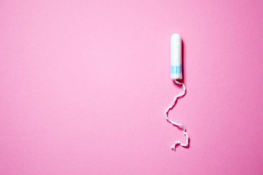 Pembe arka planda fotokopi alanı olan tıbbi kadın tamponu. Kadınlar için hijyenik beyaz tampon. Pamuklu çubuk. Regl, korunma aracı.