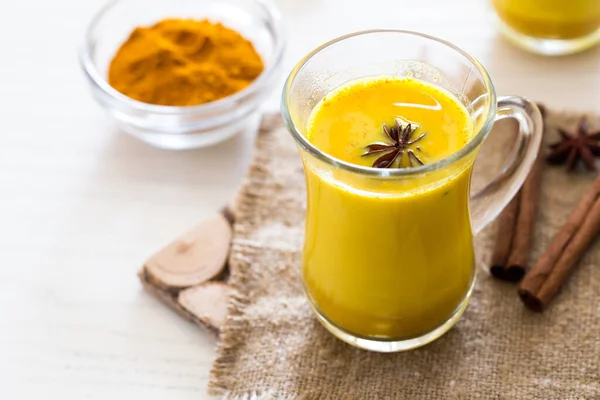 Turmeric tea drinks with milk and honey for beauty and health. Spicy healthy Haldi