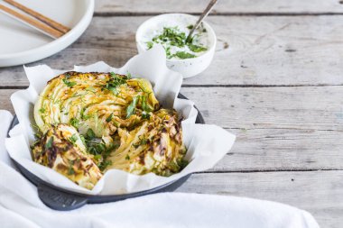 Pişmiş lahana dilimleri. Vejetaryen diyeti. Sağlıklı ızgara lahana biftekleri, ayyaş, baharat ve bitkilerle..