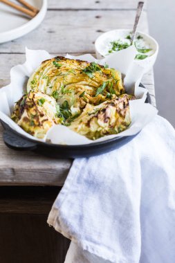 Pişmiş lahana dilimleri. Vejetaryen diyeti. Sağlıklı ızgara lahana biftekleri, ayyaş, baharat ve bitkilerle..