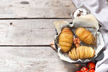 Hasselback patatesleri. Tahta masada tavada fırında patates.