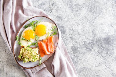 Yumurtalı kahvaltı. Yumurta, somon, avokado sandviçi ve bezelye tohumlu sağlıklı besleyici bir kahvaltı..